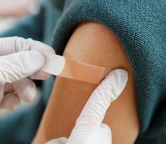 Band aid being placed on an arm.