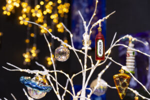 Old World ornaments depicting swimming, pizza, ketchup and the Tower of Pisa hang on a silver tree.