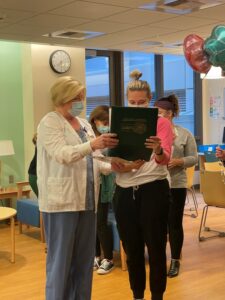 Pediatric nurse Keene is presented with The DAISY Award by a nursing colleague. 