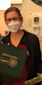 Pediatric nurse Maytorena proudly displays her DAISY Award while wearing a mask.