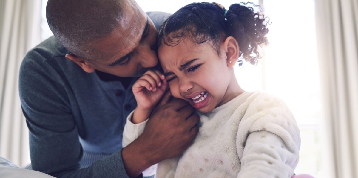 Dad consoles crying daughter