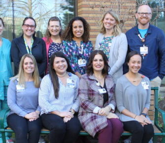 A group of Mary Bridge team members posting in front of a building.