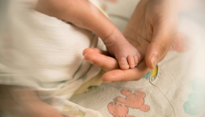 Mom holds newborn baby's foot