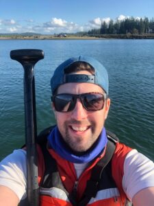 Dr. Henderson smiling while on his stand up paddle board.