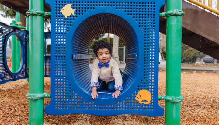 3-year-old Carlos, wearing a bow tie, plays in a playground structure