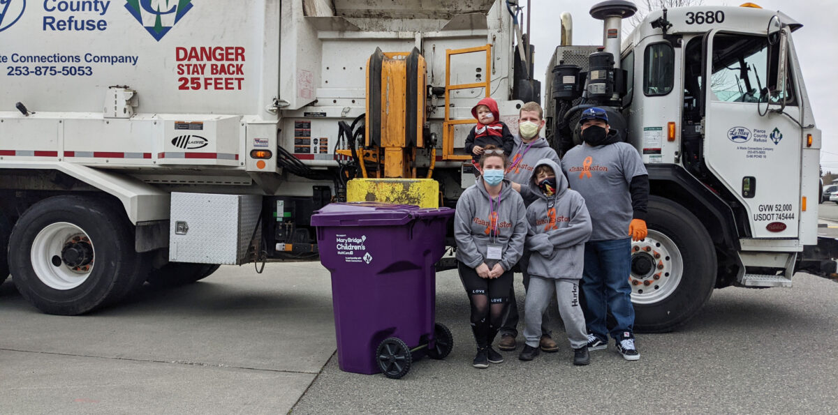 Easton and family pose with a garbage truck during a parade of garbage trucks at Mary Bridge Children’s.