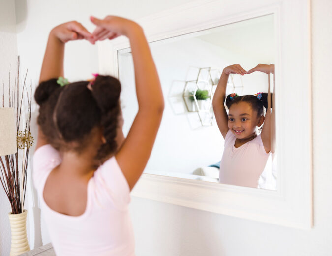 Girl smiles as she practices ballet.