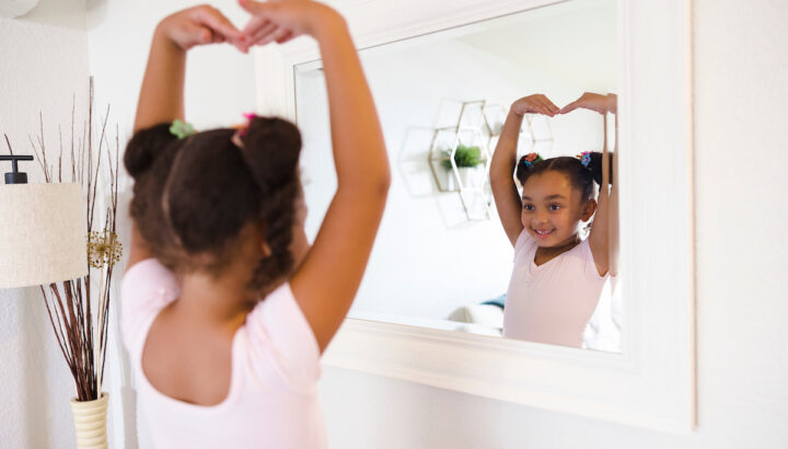 Girl smiles as she practices ballet.