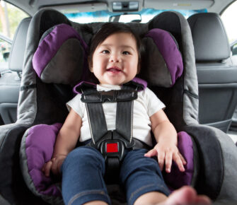 Baby sitting in car seat, all buckled in.