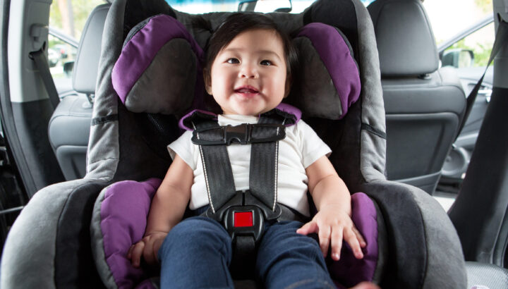 Baby sitting in car seat, all buckled in.