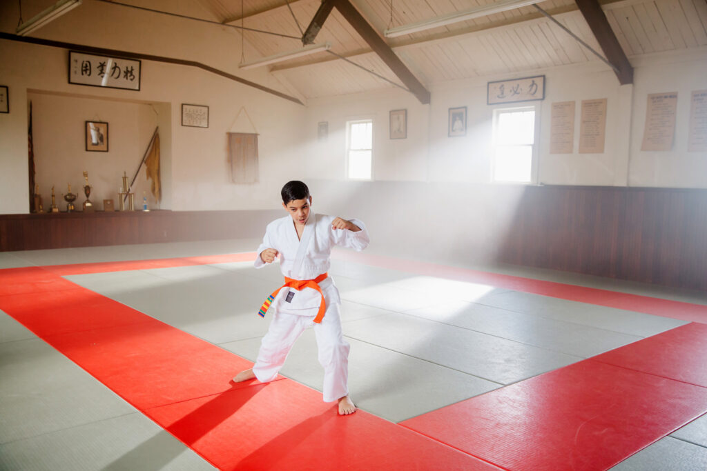 James practicing his karate in a training gym.