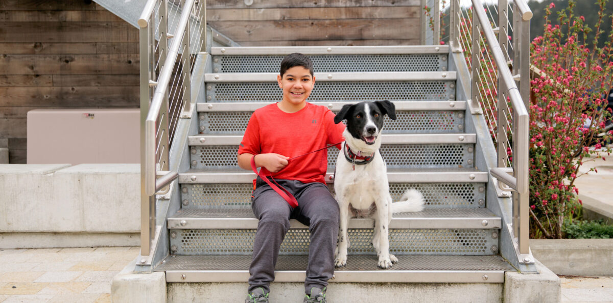 James sits on the steps with his dog.