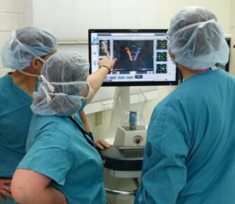 Surgeons looking at a screen.