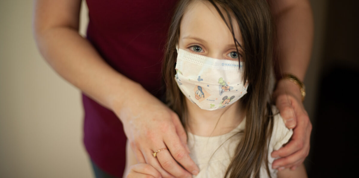 Young girl wearing procedure mask.