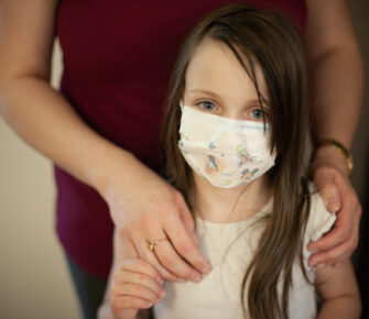 Young girl wearing procedure mask.