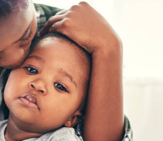 Mother comforting sick child.