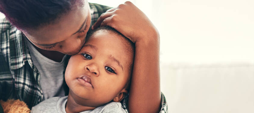 Mother comforting sick child.