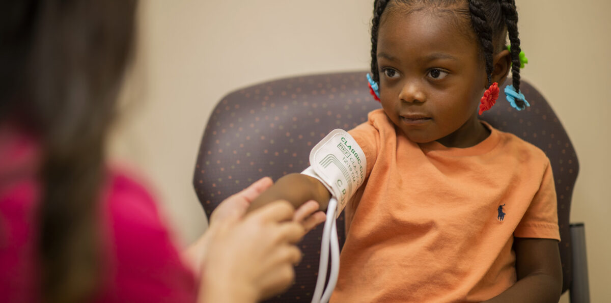 Young girl has her blood pressure checked in a doctor's office.