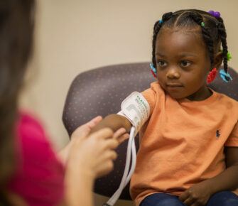 Young girl has her blood pressure checked in a doctor's office.