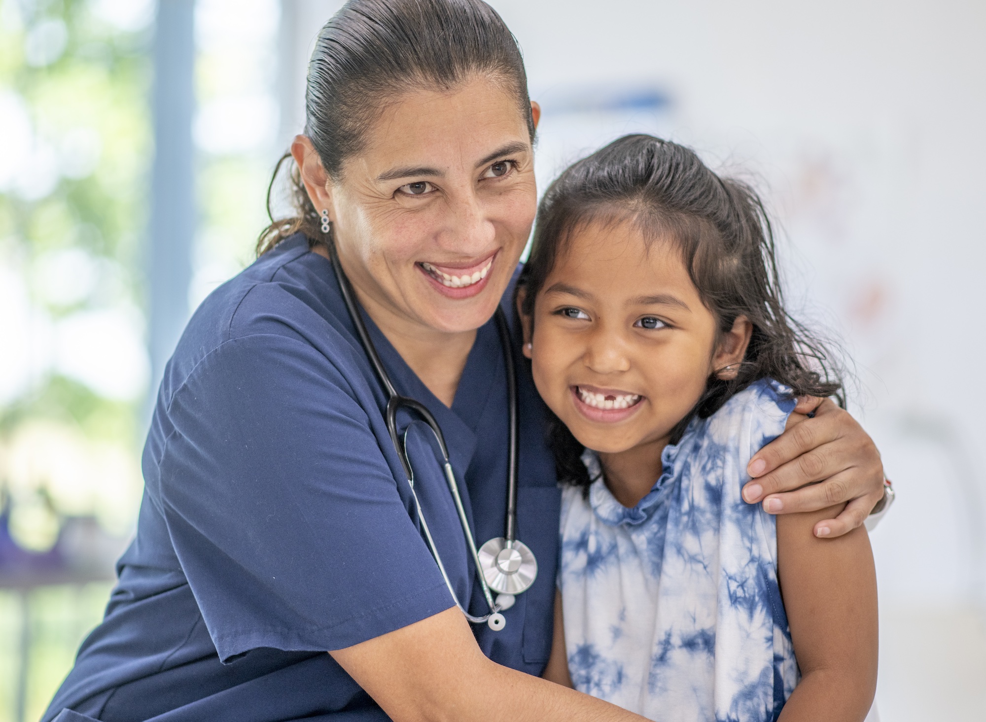 Little girl interacts with the female doctor at a medical appointment.