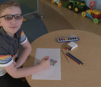 Boy sitting at a table coloring.