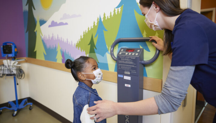 Little girl gets weighed at pediatrician