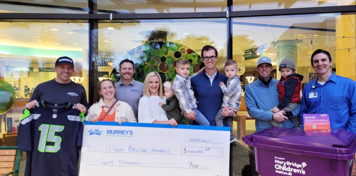 A group of people from Wast Connections holds a giant check made our to Mary Bridge Children's for $60,000.