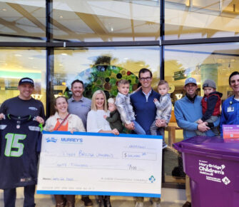 A group of people from Wast Connections holds a giant check made our to Mary Bridge Children's for $60,000.