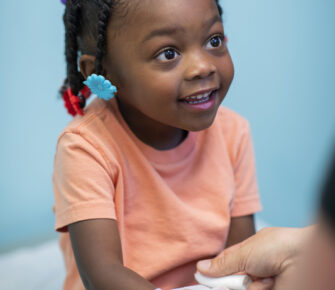 Young girl has her arm bandaged.